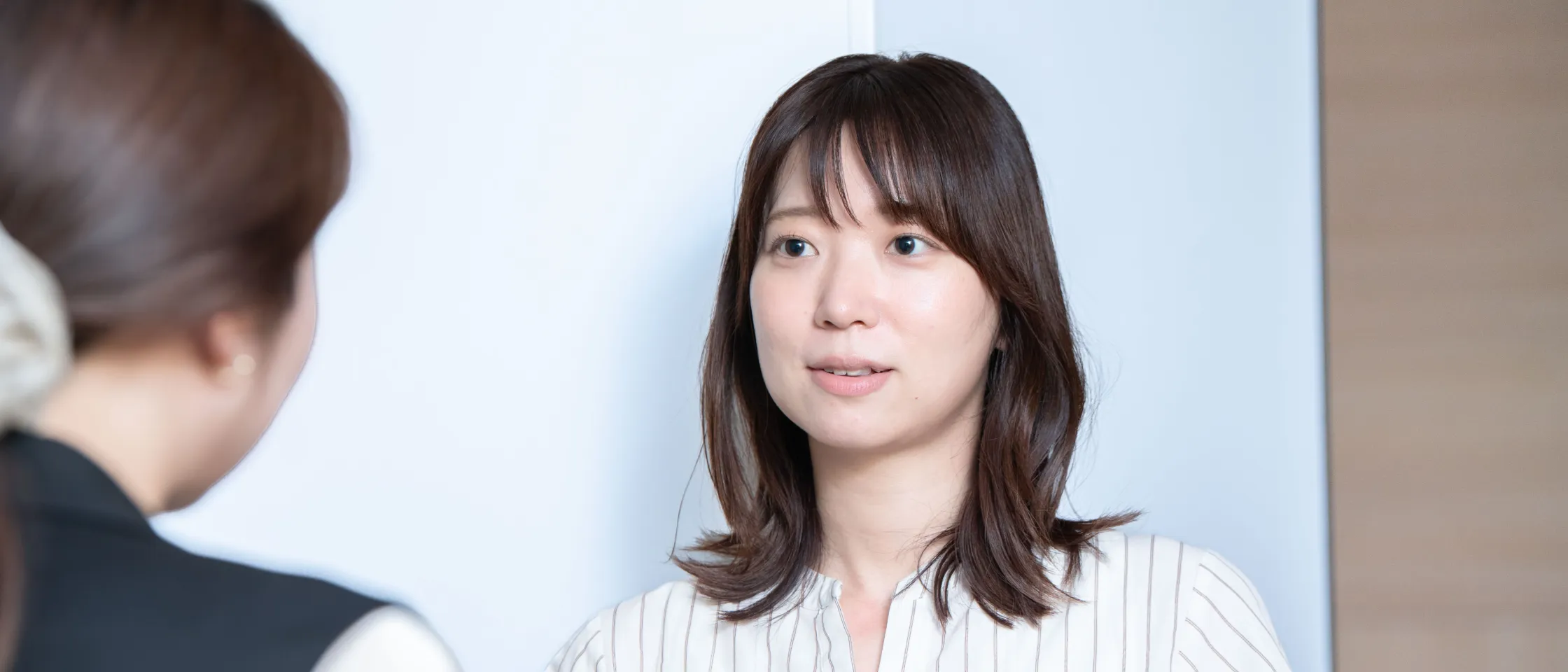 同僚と会話する社員
